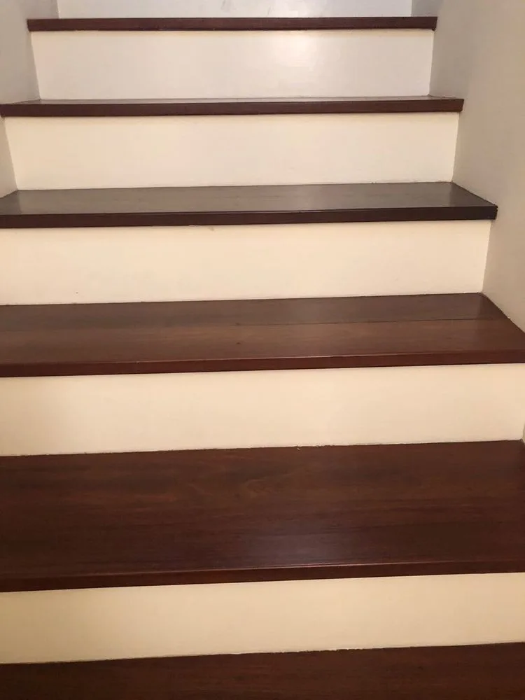 Dark hardwood staircase with white risers installed by The Flooring Design Center